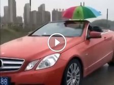 Bizarre Video Shows Man Holding Umbrella Driving A Convertible In The Rain