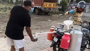 కరోనా ఎఫెక్ట్ : సామజిక దూరంతో పాలు పోస్తున్న పాల వ్యాపారి