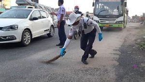 చీపురు పట్టి రోడ్డు శుభ్రం చేసిన ట్రాఫిక్ పోలీస్.. ఎందుకో తెలుసా ?