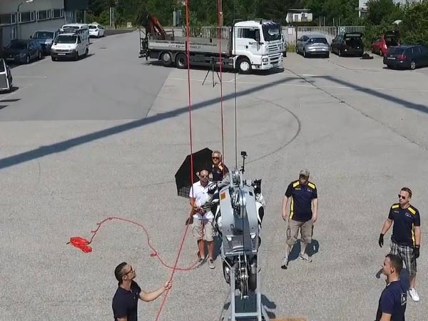 guenter-schachermayr-to-ride-motorcycle-on-steel-cable-suspended-between-black-haw-helicopters