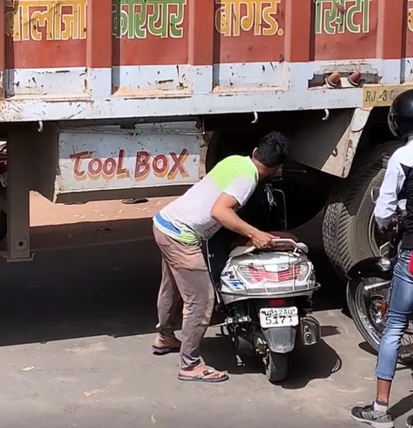 ರಸ್ತೆಗೆ ಅಡ್ಡ ನಿಂತಿದ್ದ ಟ್ರಕ್ ಕೆಳಗೆ ಸ್ಕೂಟರ್ ನುಗ್ಗಿಸಿದ ಯುವಕ 