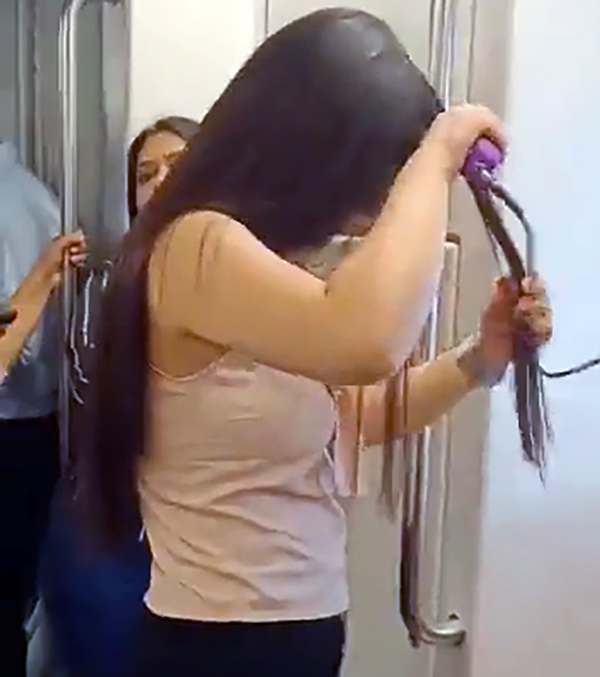 woman-using-hair-straightener-in-delhi-metro