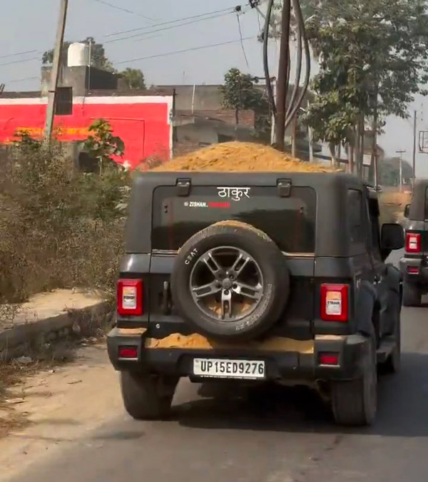 man drives thar with pile of sand on top