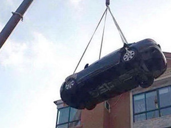 கிரேனில் தூக்கப்படும் கார்