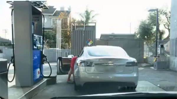 டெஸ்லா எலெக்ட்ரிக் காருக்கு பெட்ரோல் நிரப்ப முயன்ற பெண்... !!