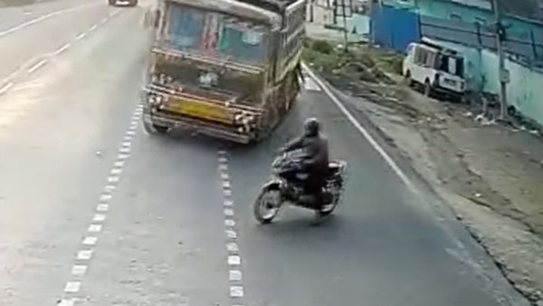 மயிரிழையில் உயிர் தப்பிய பைக் ஓட்டுனர்- லாரி வந்த வேகத்திற்கு மோதி இருந்தால்... நினைத்து கூட பார்க்க முடியல...