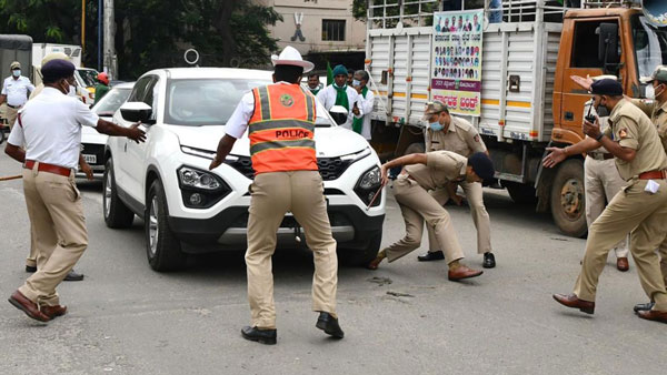 துணை போலீஸ் கமிஷ்னரின் காலின் மீது காரை ஏற்றிய போராட்டக்காரர்!! சிறிதுநேரத்தில் பரபரப்பாகிய முக்கிய சாலை