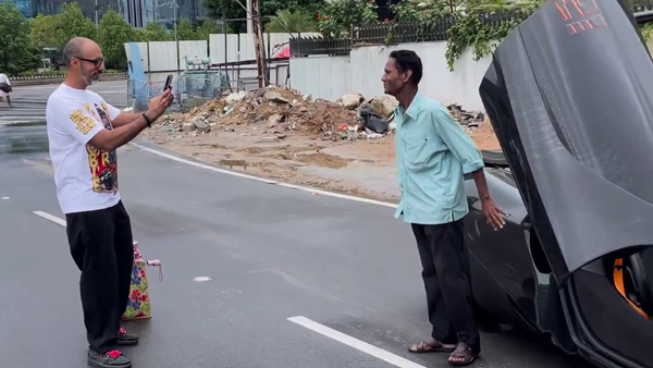 Man poses with mclaren car