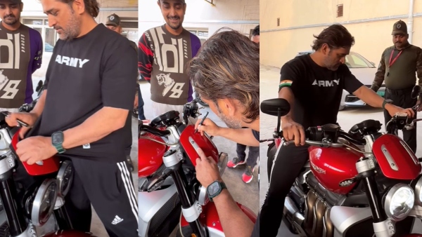 Dhoni autographing on fan bike