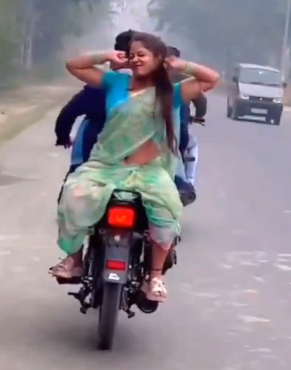 Women giving flying kiss on moving bike
