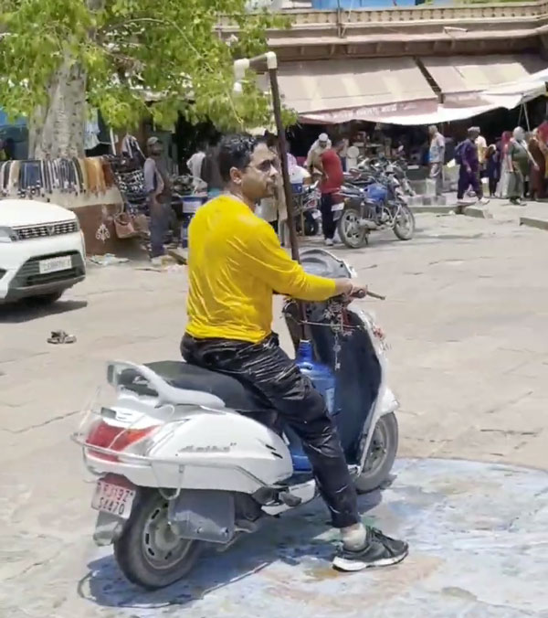 man installing shower on scooter