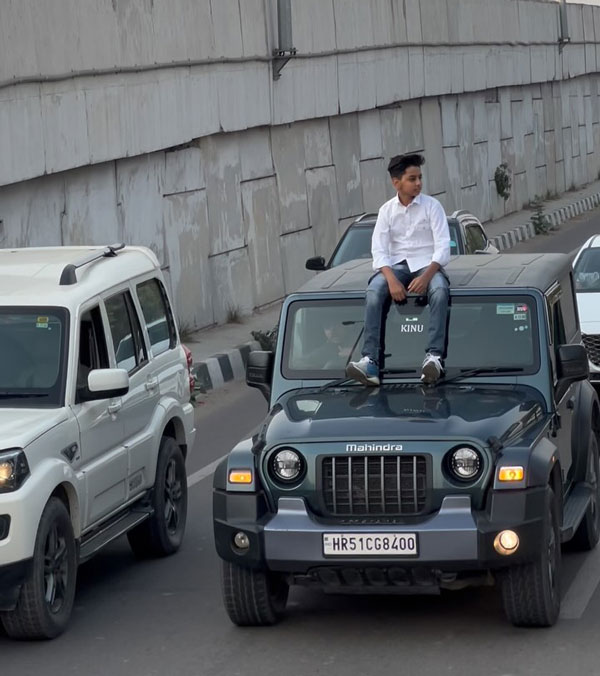 boy on mahindra thar roof