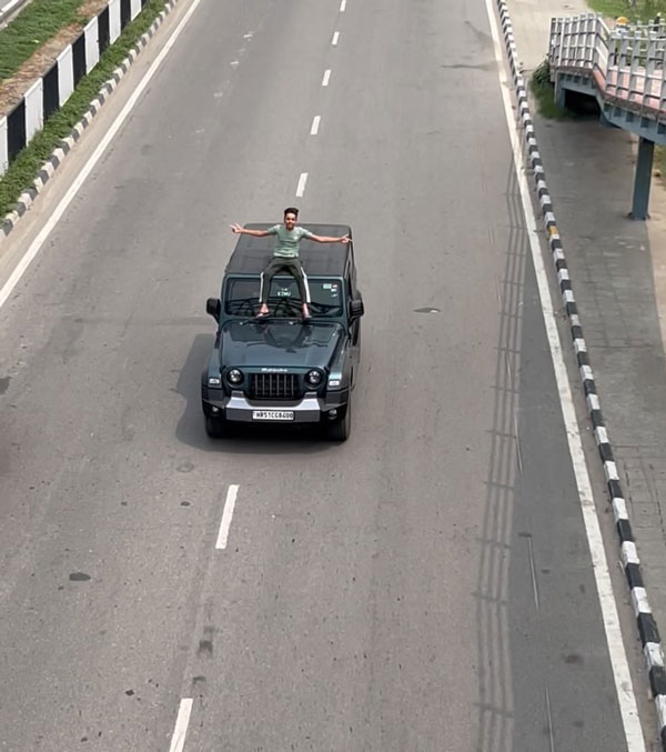 boy on mahindra thar roof