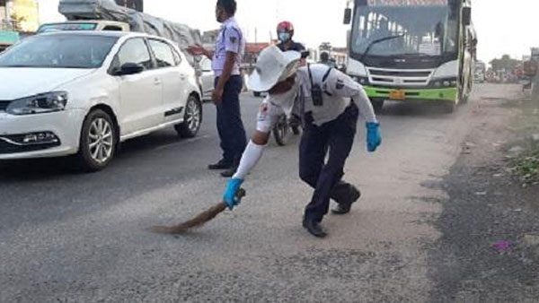 చీపురు పట్టి రోడ్డు శుభ్రం చేసిన ట్రాఫిక్ పోలీస్.. ఎందుకో తెలుసా ?