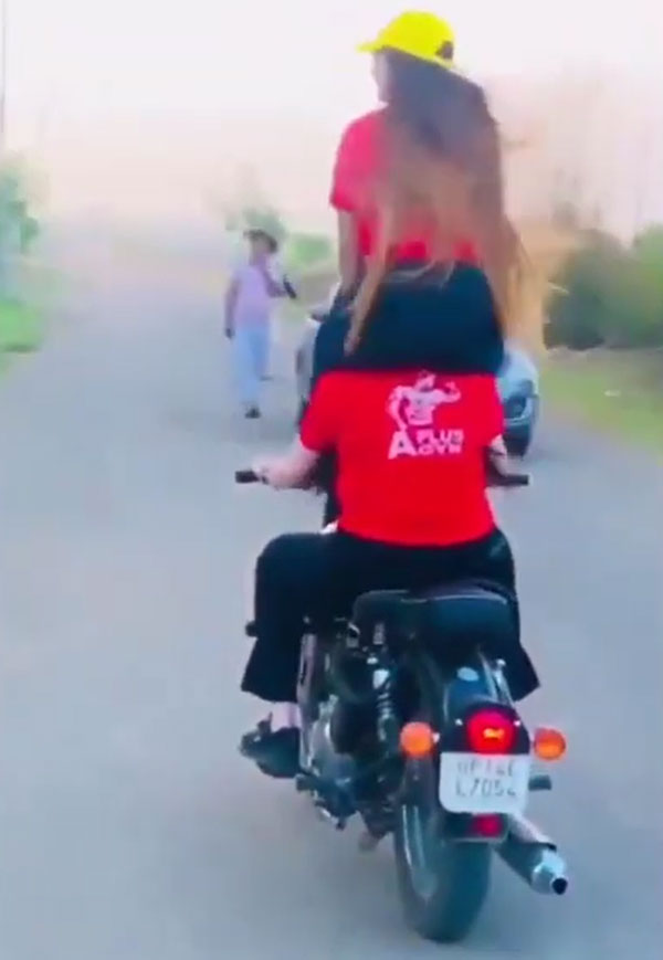 ఒకరిపై ఒకరు కూర్చుని ప్రమాదకరమైన బైక్ స్టంట్స్ చేసిన యువతులు