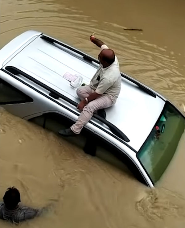 ట్రాక్టర్ వల్ల బయటపడ్డ వర్షపు నీటిలో చిక్కుకున్న Toyota కారు: వీడియో 