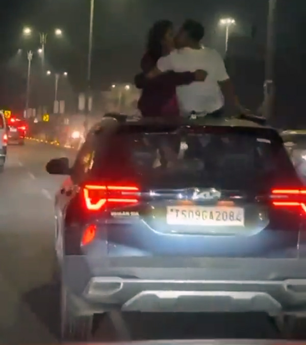 couple get cosy on roof of a moving car