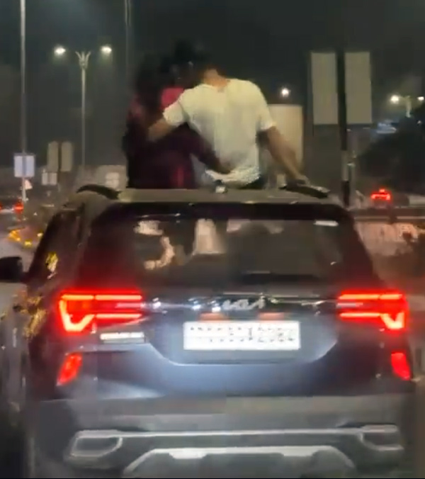 couple get cosy while on roof of a moving car