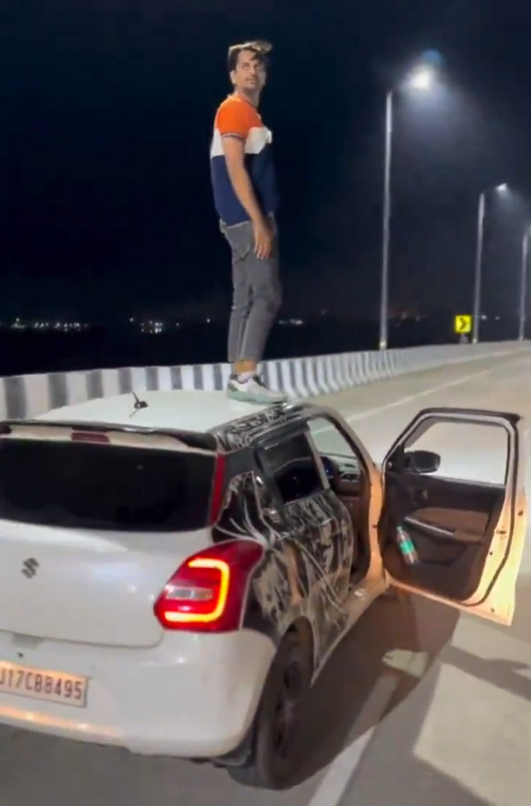 Man-Stunts-On-Running-Car