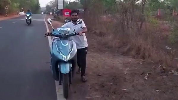 Man Pushes Electric Scooter Charging